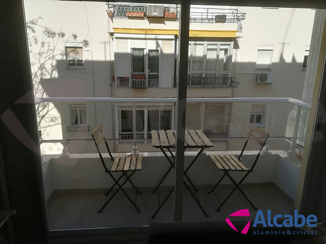 Colocación e instalación de Barandilla de Cristal para balcón o terraza, con pasamanos de aluminio lacado en blanco, en Los Remedios (Sevilla)