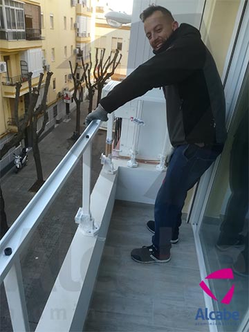 Colocación e instalación de Barandilla de Cristal para balcón o terraza, con pasamanos de aluminio lacado en blanco, en Los Remedios (Sevilla)