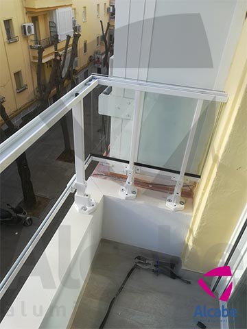 Colocación e instalación de Barandilla de Cristal para balcón o terraza, con pasamanos de aluminio lacado en blanco, en Los Remedios (Sevilla)