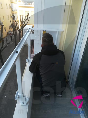 Colocación e instalación de Barandilla de Cristal para balcón o terraza, con pasamanos de aluminio lacado en blanco, en Los Remedios (Sevilla)