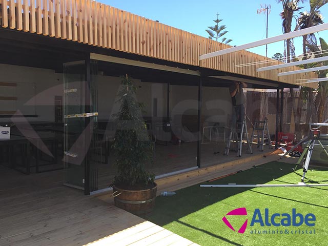 Instalación de un cerramiento completo de cortinas de cristal en Tulúm Club & Restaurant, de Chipiona, Cádiz