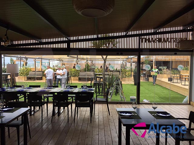 Instalación de un cerramiento completo de cortinas de cristal en Tulúm Club & Restaurant, de Chipiona, Cádiz