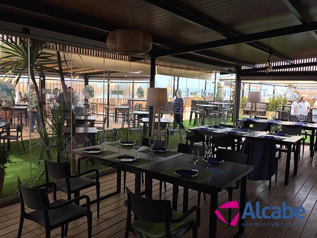 Instalación de un cerramiento completo de cortinas de cristal en Tulúm Club & Restaurant, de Chipiona, Cádiz