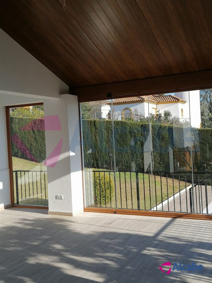Instalación de estructura de aluminio con Techo de Panel de Teja a dos aguas y Cerramiento con Cortinas de Cristal en Córdoba