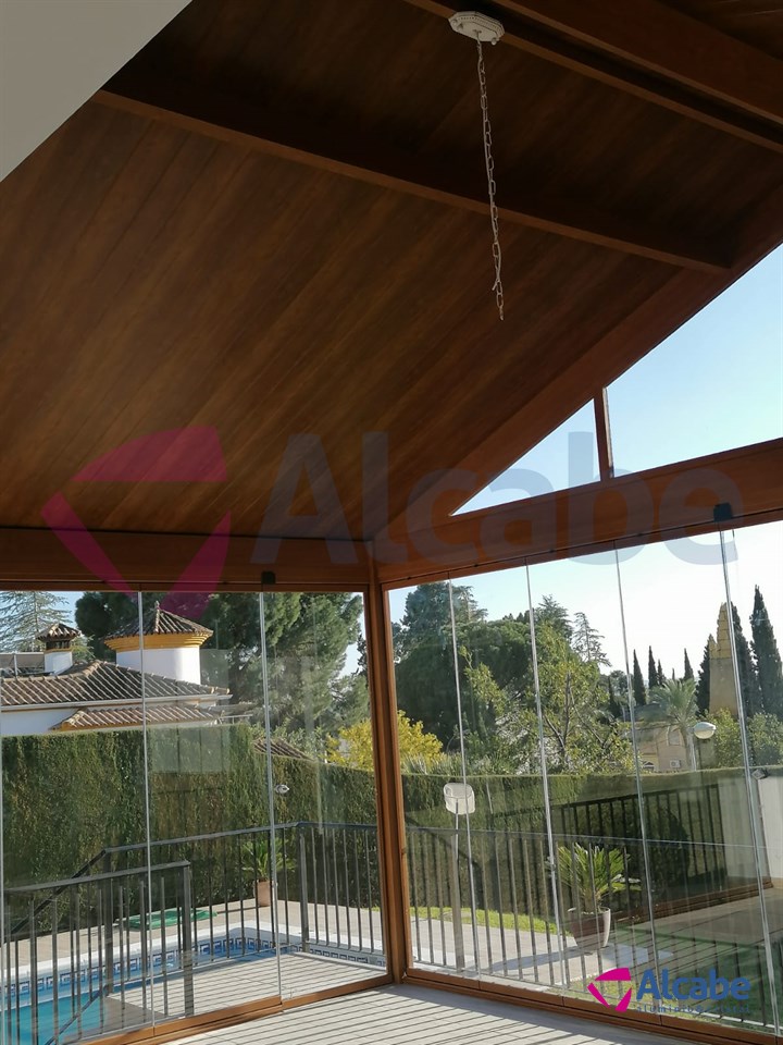 Instalación de estructura de aluminio con Techo de Panel de Teja a dos aguas y Cerramiento con Cortinas de Cristal en Córdoba