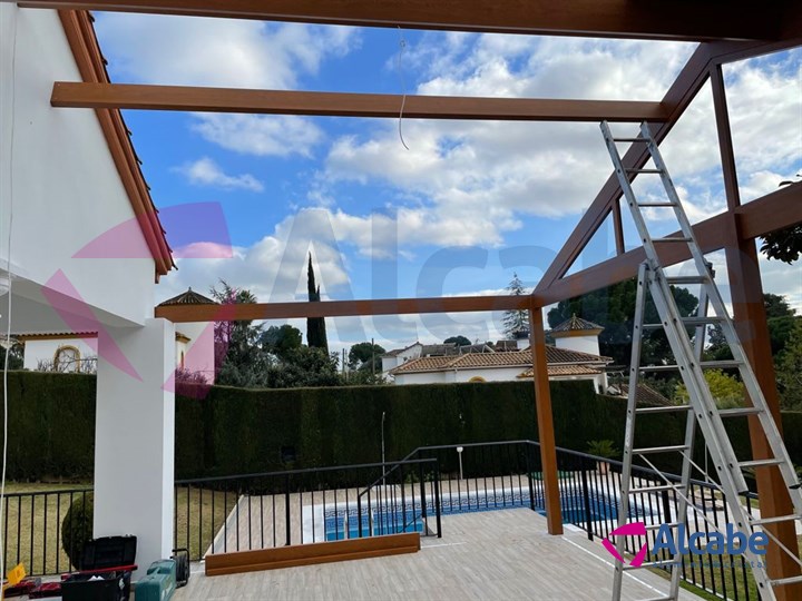 Instalación de estructura de aluminio con Techo de Panel de Teja a dos aguas y Cerramiento con Cortinas de Cristal en Córdoba
