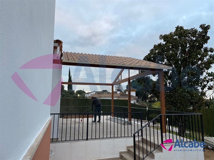 Instalación de estructura de aluminio con Techo de Panel de Teja a dos aguas y Cerramiento con Cortinas de Cristal en Córdoba
