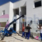 Elevación y colocación de cristales con minigrúa, en vivienda unifamiliar de Huelva